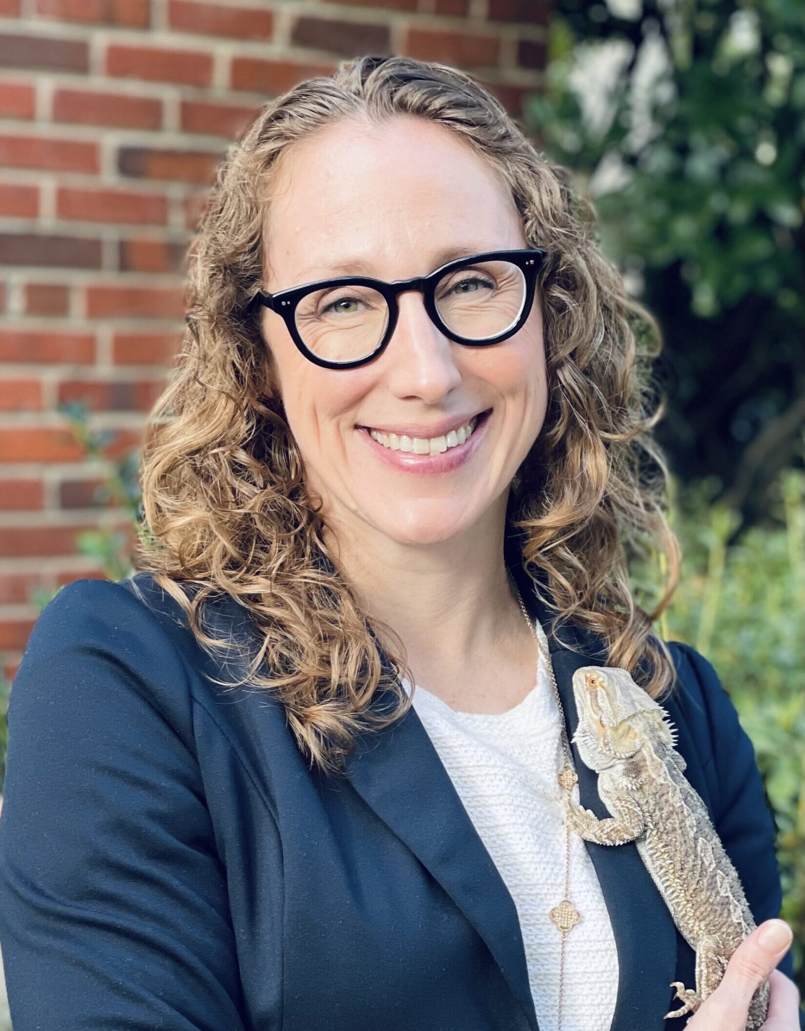 headshot of Tanya Boris-Cass, bearded dragon on her lapel